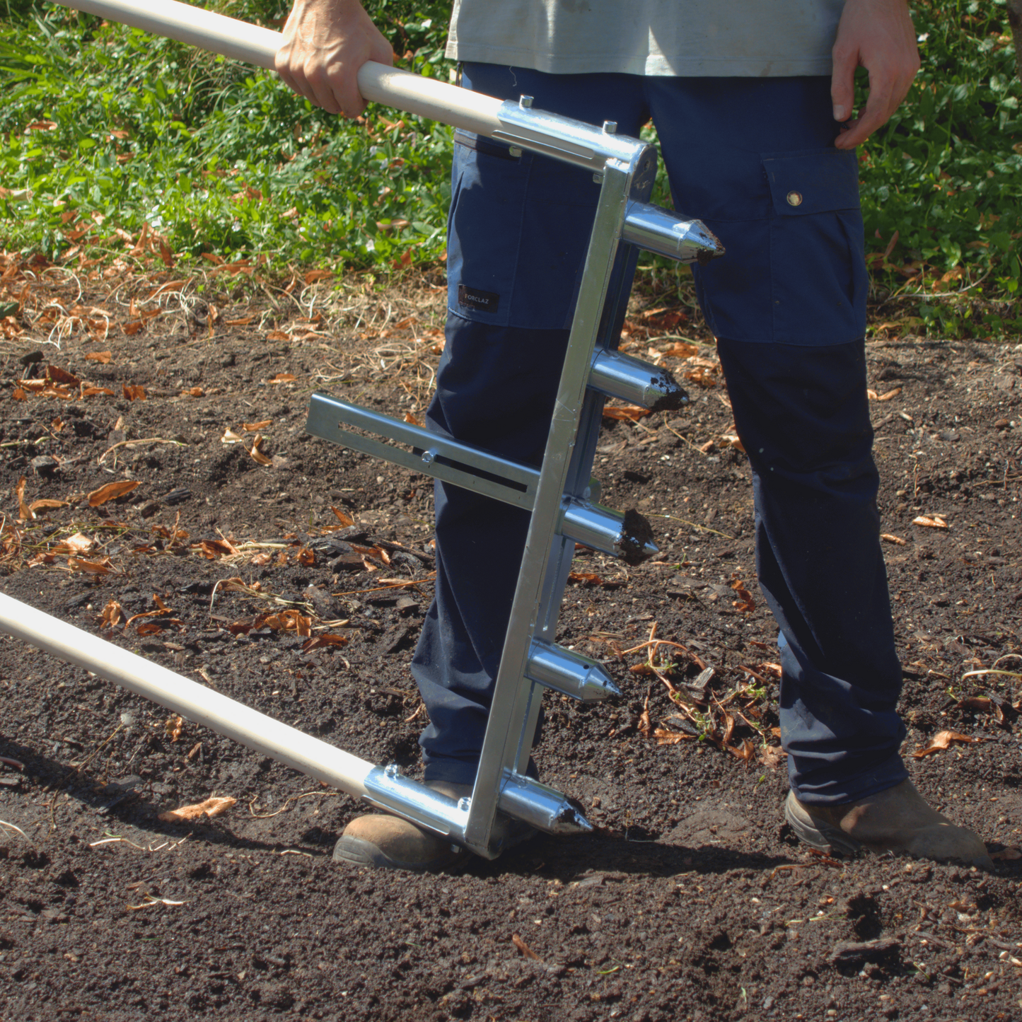 Person using Green Tools Tech Multi Dibbler with adjustable dibbles and row marker for fast no-dig market garden transplanting on 75 cm beds