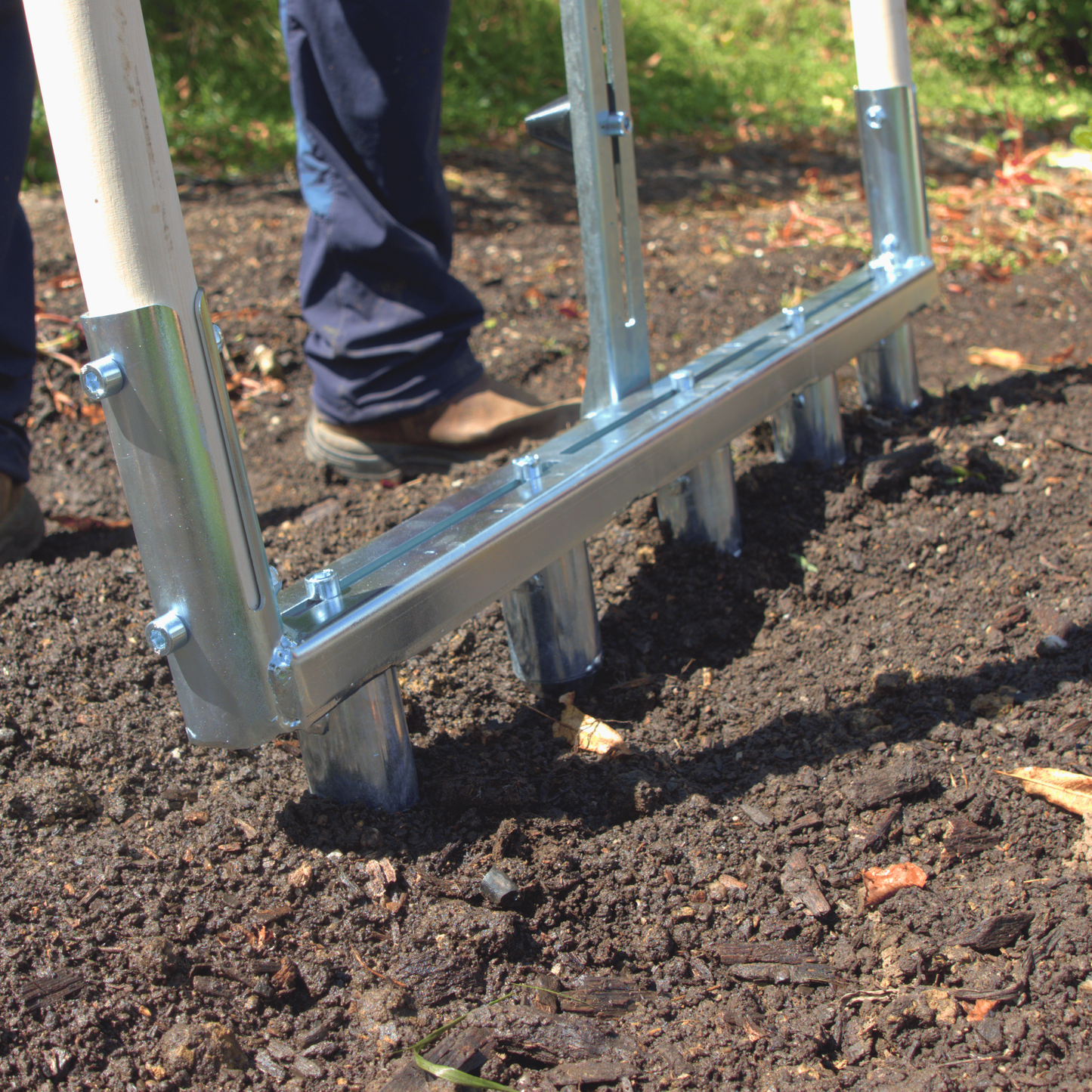 A close up of a Green Tools Tech Multi Dibbler with adjustable dibbles and row marker for fast no-dig market garden transplanting on 75 cm beds
