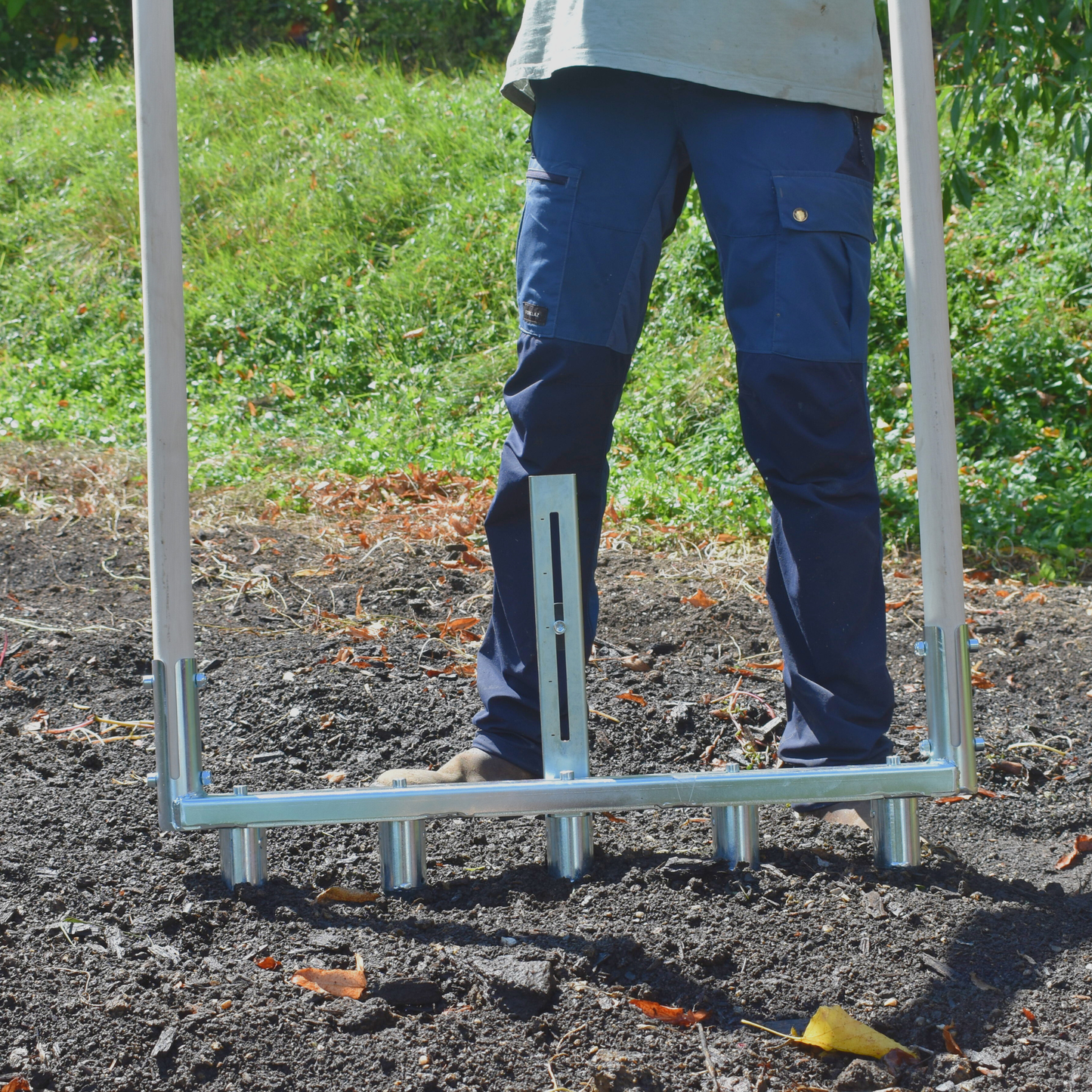 Person using Green Tools Tech Multi Dibbler with adjustable dibbles and row marker for fast no-dig market garden transplanting on 75 cm beds