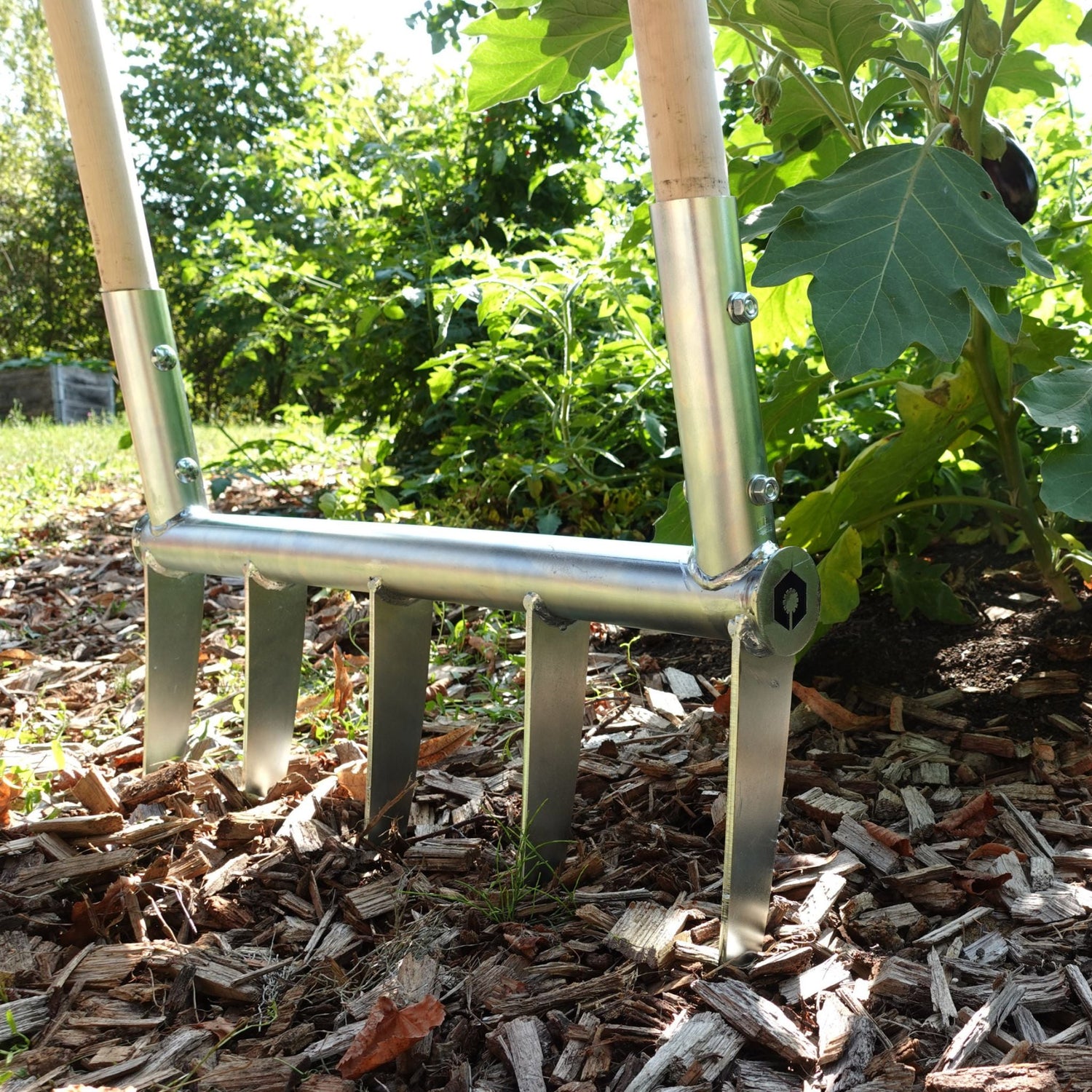 Market Garden Tools: Close-up of a sturdy broadfork in a lush vegetable garden.