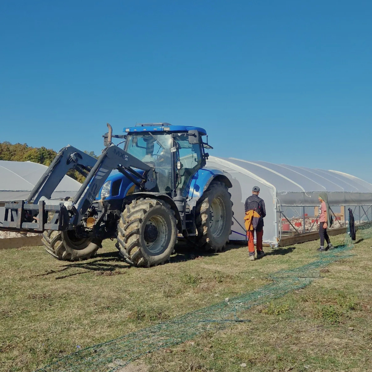 Traktor pokraj Hoop Coop kokošinjaca na pašnjaku
