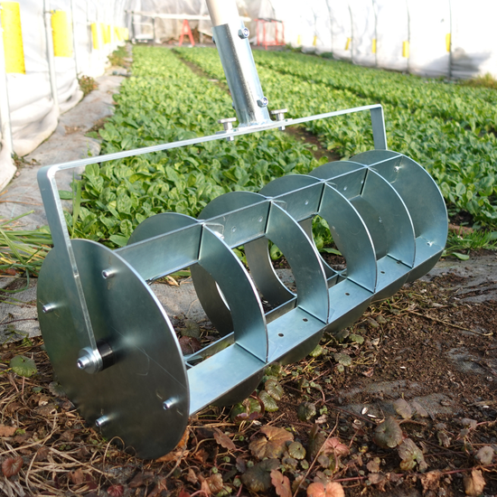 A Green Tools TECH Grid Marker being used for laying out a precise planting grid on a no-dig market garden bed.
