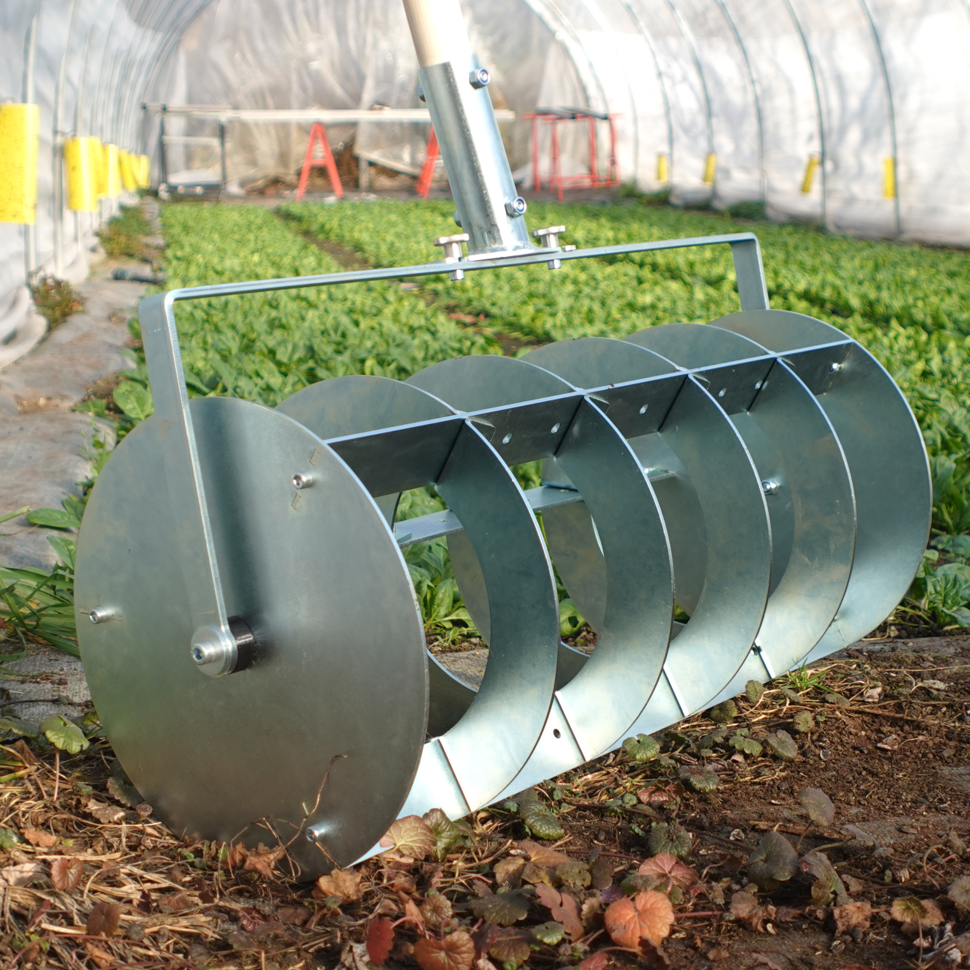 A Green Tools TECH Grid Marker being used for laying out a precise planting grid on a no-dig market garden bed.