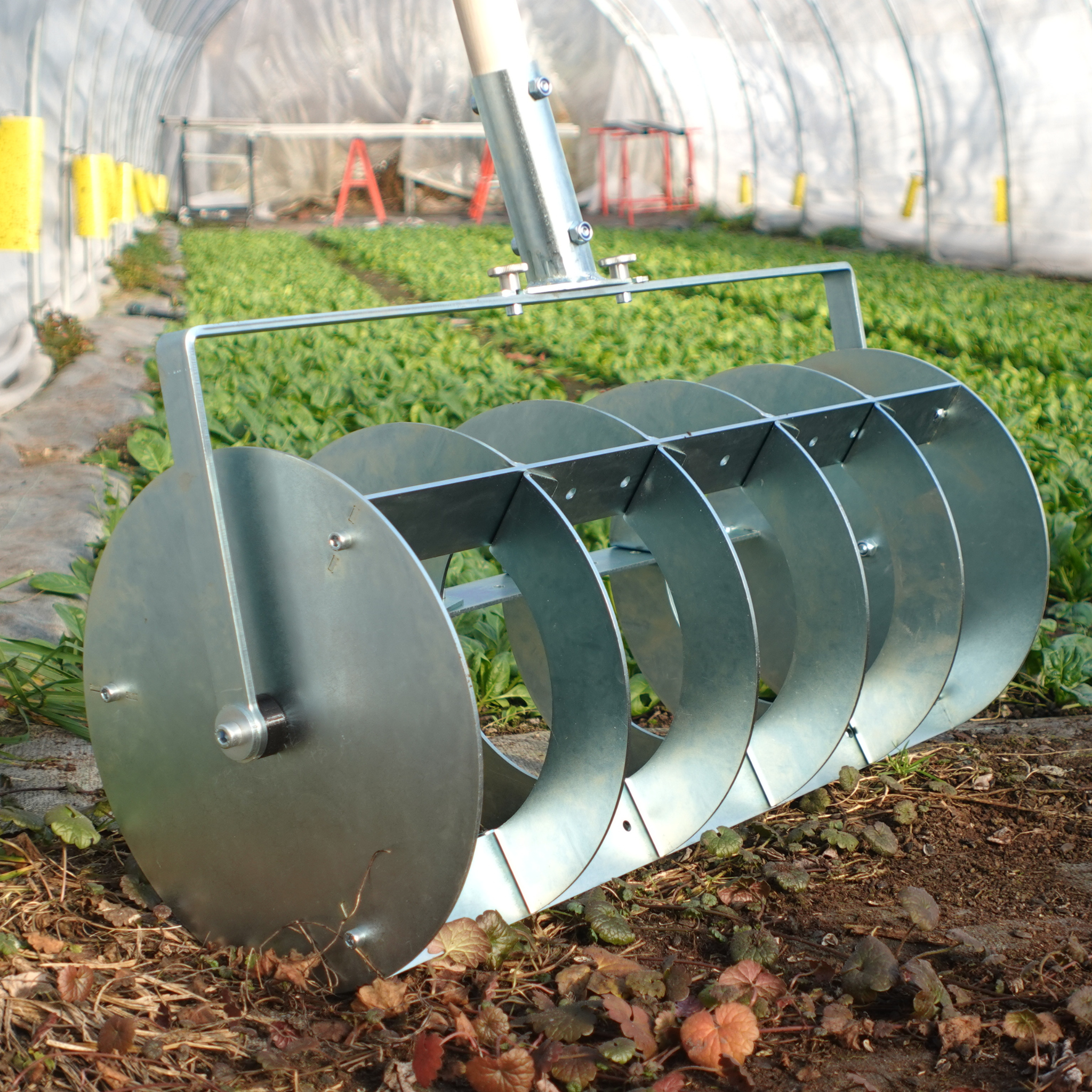 A Green Tools TECH Grid Marker being used for laying out a precise planting grid on a no-dig market garden bed.