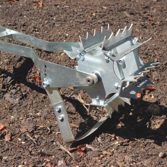 A person using Green Tools TECH Roto Hoe for weeding and soil cultivation in a no-dig market garden.